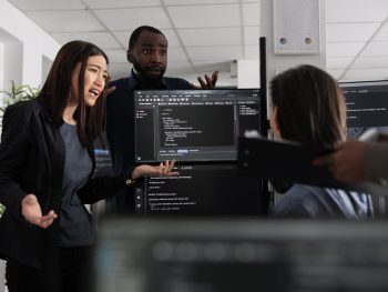 Diverse web developers collaborating about programming project talking about coding algorithm for new cloud computing user interface. team of software engineers running database system code.