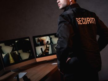 partial view of guard in black uniform at workplace